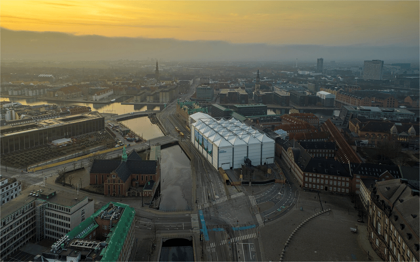 Aerial view of copenhagen at sunrise with a sitecover building near canals