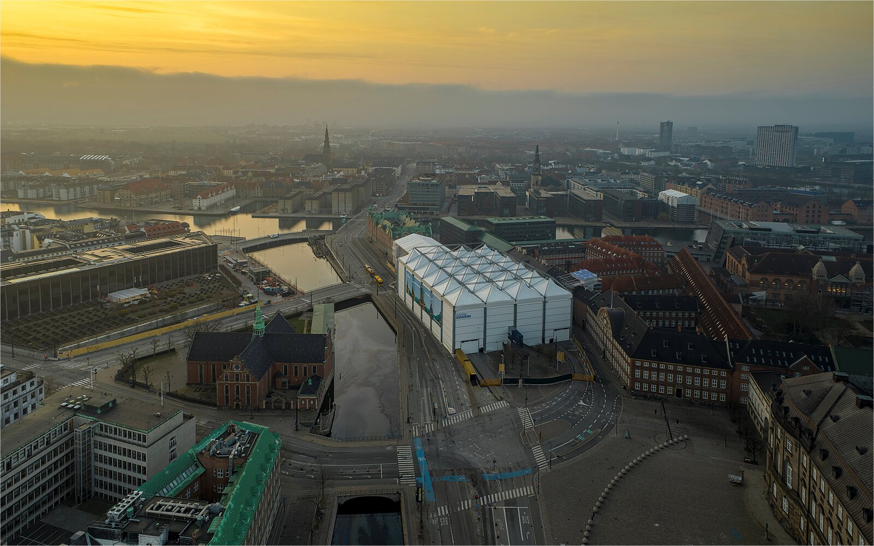 Aerial view of copenhagen at sunrise with a sitecover building near canals
